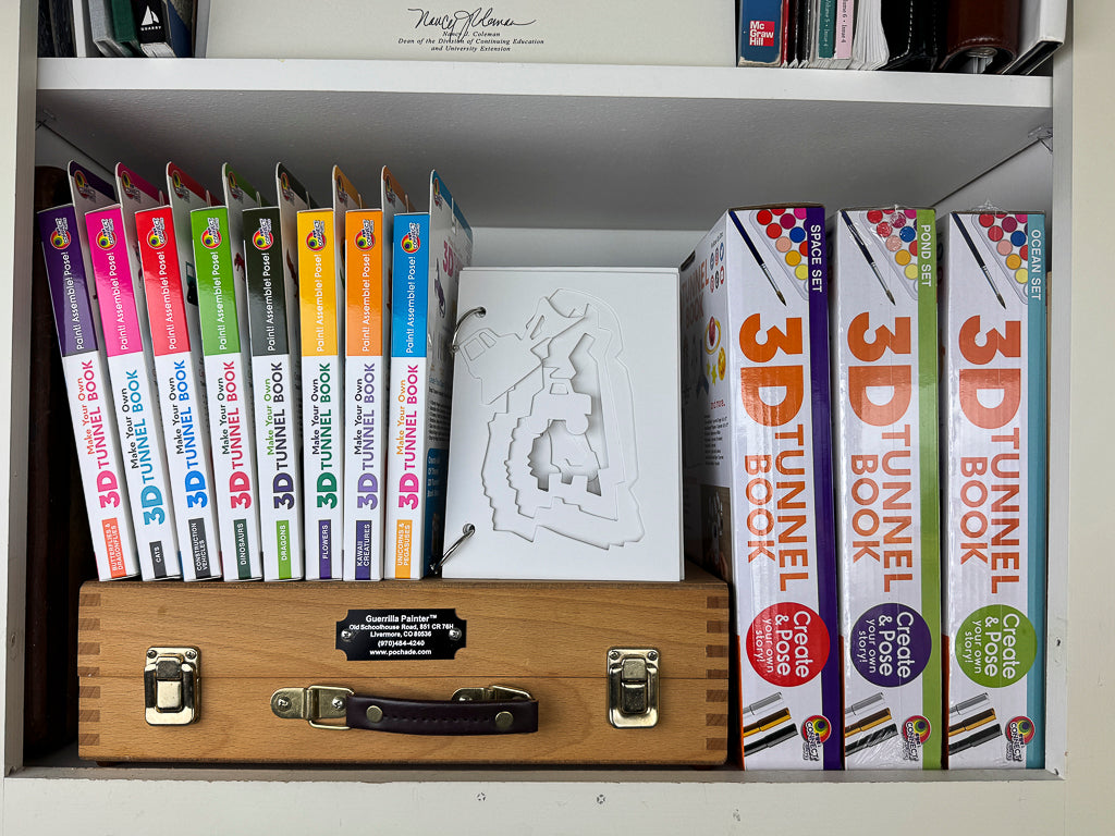 The assembled unpainted DIY 3D Tunnel Book, Construction Vehicles art and craft kit featured on a bookshelf.