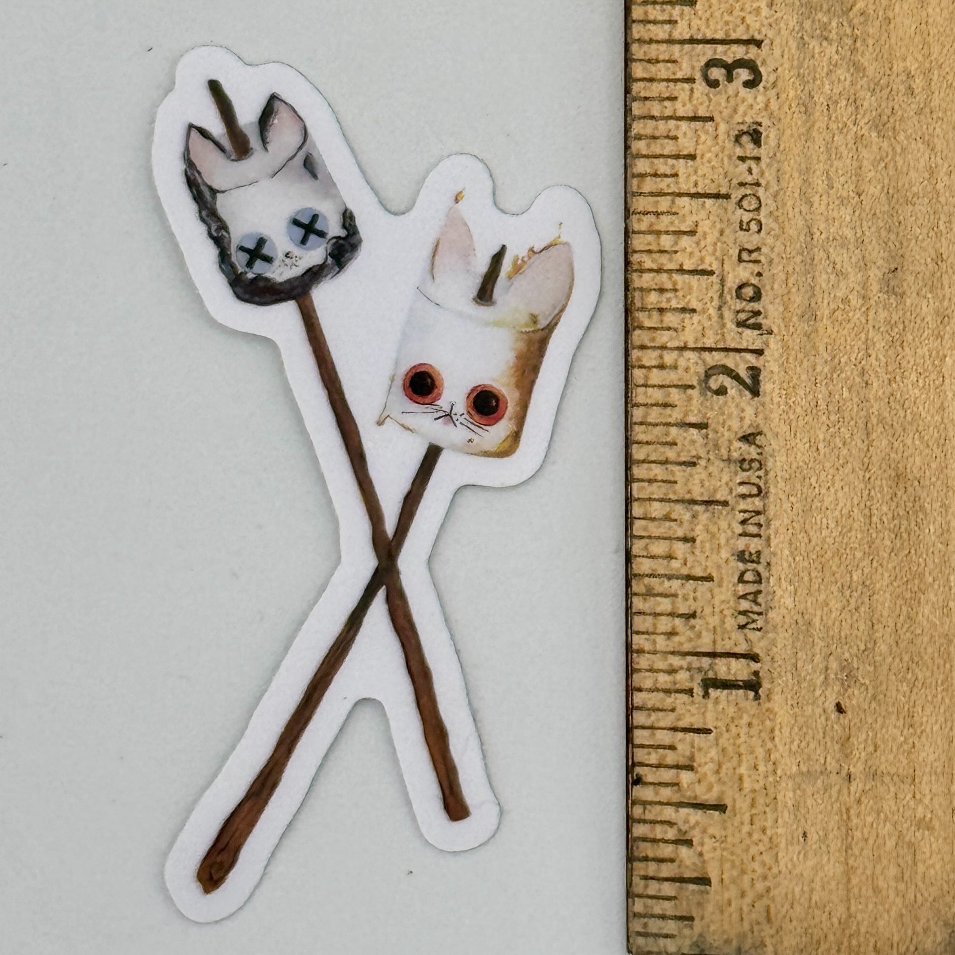Sticker of a the Roasted and Toasted KittenMallow next to a ruler for scale